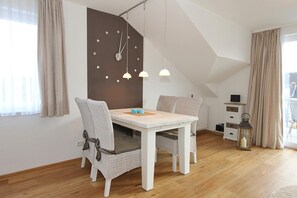 A modern, well-lit room with a dining table, chairs, and pendant lights. - Domizil am Möwenberg - Domizil am Möwenberg Apartment 9 (Scharbeutz)