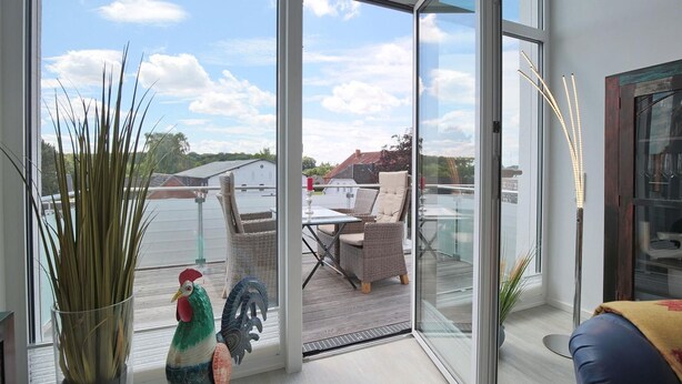 A modern room with large glass doors leading to an outdoor patio area.