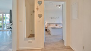 Ein Hotelzimmer mit einem Bett, einem Nachttisch und einem Spiegel. An der Wand befinden sich herzförmige Verzierungen und ein Schild mit Text.