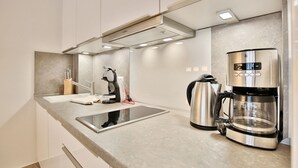 A modern kitchen with a Bosch coffee maker, a kettle, and a sink. - Seerose II Apartment 14 - House Seerose (Scharbeutz)