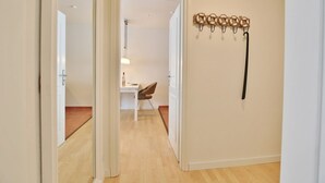 A hallway with a wooden floor, a white door, and a wall-mounted coat rack. - Seerose II Apartment 14 - House Seerose (Scharbeutz)