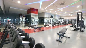 A modern gym with various exercise equipment, including dumbbells, benches, and weight machines. - VS Hotel (Quezon City)