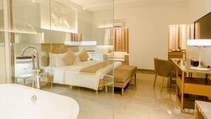 A modern hotel room with a glass shower enclosure, a large bed with a headboard, a desk with a chair, and a flat-screen TV. - VS Hotel (Quezon City)