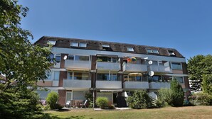 A multi-story residential building with balconies, satellite dishes, and outdoor seating areas. - Domizil Seestraße - Ihr Domizil Seestraße (Scharbeutz)