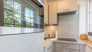 A modern kitchen with a window, stainless steel appliances, and a wooden sign.
