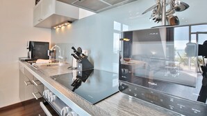 A modern kitchen with a built-in microwave, a coffee machine, and a sleek countertop.