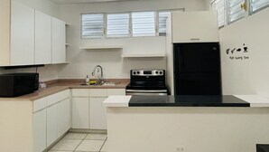 A compact kitchen with white cabinets, a black stove, a sink, and a window above the sink. - 5** Start New Beautiful Aparment w/ 2 Bedrooms. (San Juan)