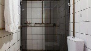 Ein Badezimmer mit Toilette, Waschbecken, Spiegel und Duschkabine.