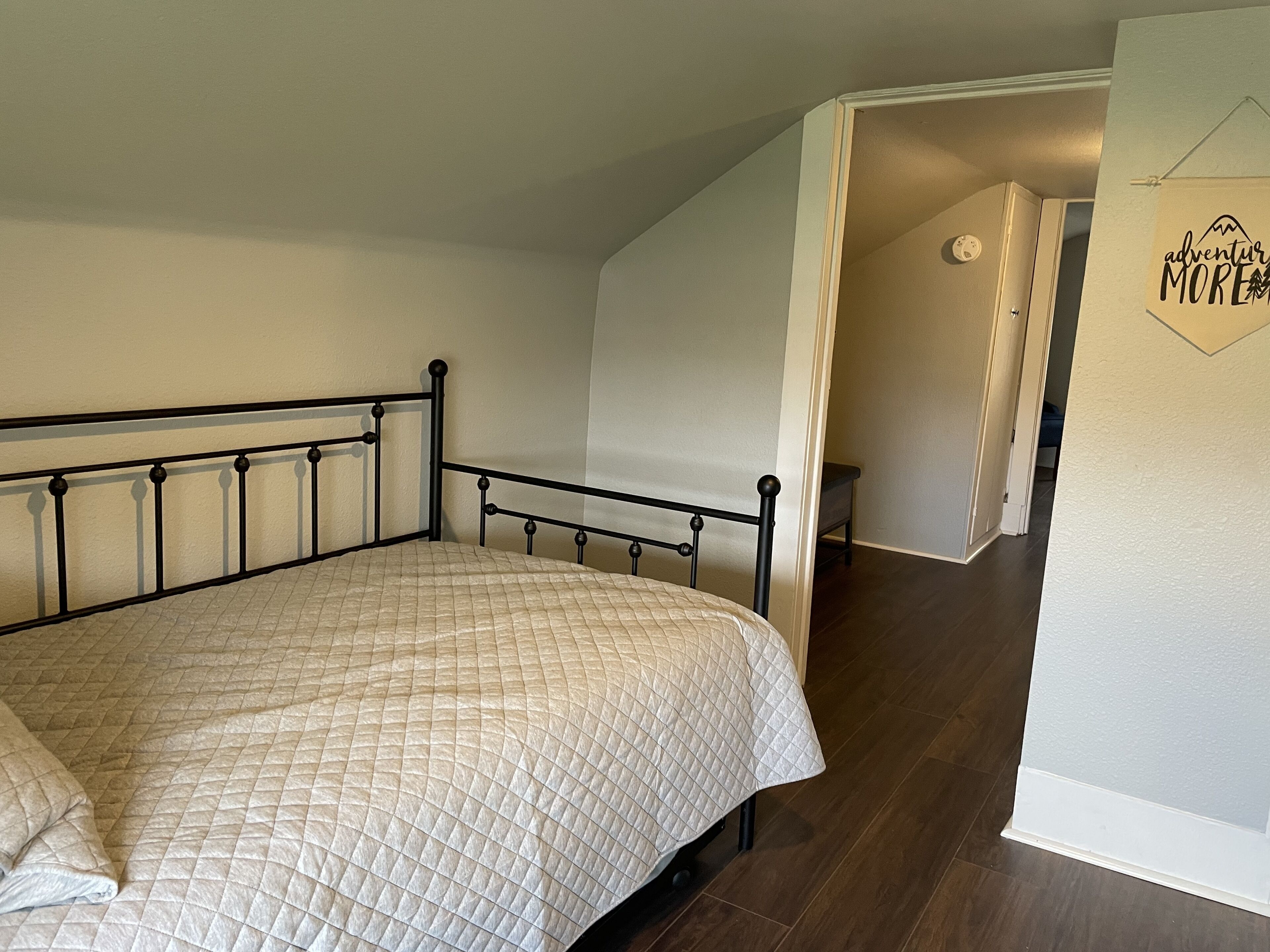 Una camera da letto con un letto, una porta e un muro con un cartello.