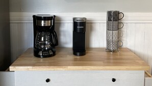 A kitchen counter with a coffee maker, a Keurig, and a mug holder.