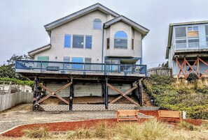 A two-story house with a balcony, a garage, and a wooden deck. - Experience Spacious Coastal Living at Seascape - Stunning Views of Heceta Beach  (Florence)