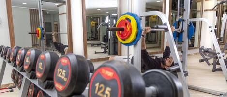 A gym with weightlifting equipment, including dumbbells and barbells.