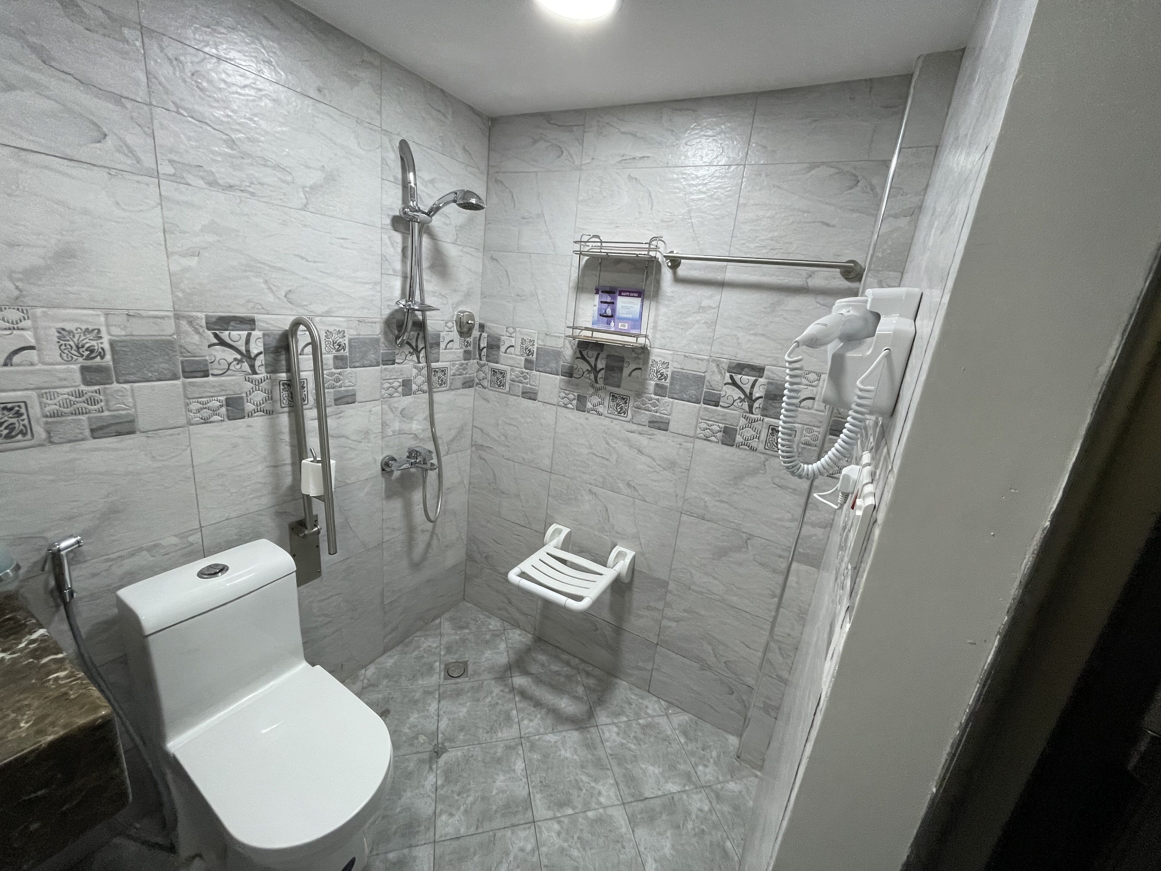 Ein Badezimmer mit Toilette, Dusche und Handtuchhalter.