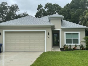 A single-story house with a garage, a front door, and a small porch area. - Discount for 30+day stays, fast Wi-Fi, work desk! Pet friendly! Close to beaches (Nokomis)