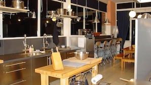 A modern kitchen with stainless steel appliances, wooden countertops, and hanging pots. - Beautiful country house in the Ardennes with lots of privacy (Nisramont-La Roche)