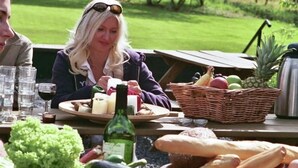 A picnic setup with food items, a bottle, and a basket on a table outdoors. - Beautiful country house in the Ardennes with lots of privacy (Nisramont-La Roche)