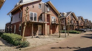 A modern residential building with a flat roof, large windows, and a balcony. - Uitgeest Apartment with Waterpark Nearby (Uitgeest)