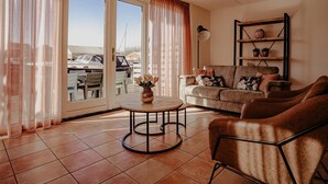A living room with a sofa, a coffee table, and a bookshelf. - Uitgeest Apartment with Waterpark Nearby (Uitgeest)