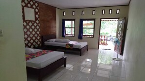 A hotel room with two beds, a large window with curtains, a fan, and a view of the outside. - Home Stay Muhrodin (Borobudur)