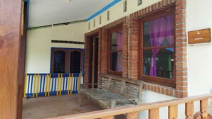 A building with a porch, a wooden bench, and a sign that reads "SOBRUDU". - Home Stay Muhrodin (Borobudur)