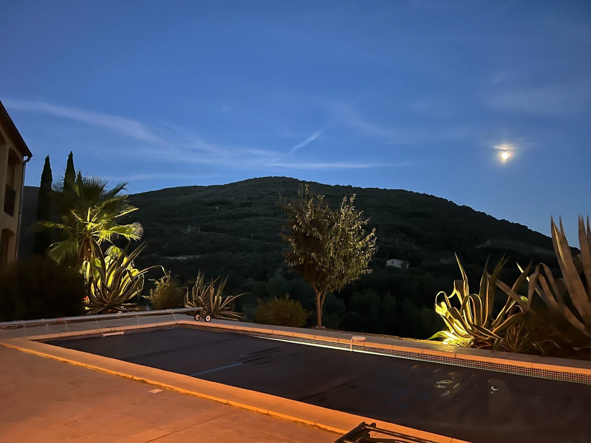 Ein Schwimmbecken mit Blick auf einen Berg in der Abenddämmerung.
