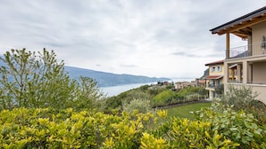A residential area with a view of a lake, surrounded by greenery and houses. - Apartment 'Residence La Villa Principe' with Garden, Pool & Wi-Fi (Tignale Aer)