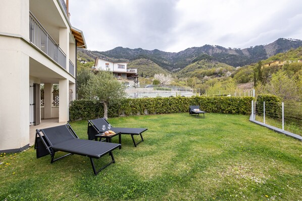 Une propriété résidentielle dotée d’un balcon, d’une cour verdoyante et offrant une vue sur les montagnes.