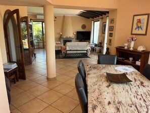 A spacious living area with a fireplace, a television, and a dining table with chairs. - Villa Javea Balcon al Mar-seaview with Pool & Wi-Fi (Jávea)