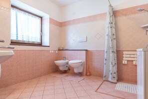 Une salle de bain avec deux lavabos, une douche et une fenêtre.