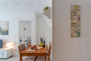 Un coin repas avec une table en bois, des chaises et un panier de fruits.
