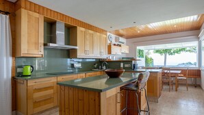Una cocina con armarios de madera, encimera verde, una tetera y un bol.