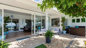 Un patio moderno al aire libre con comedor, asientos y plantas en macetas.