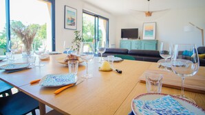 A dining table set with plates, cutlery, glasses, and a lemon. - -GAÏA- MAISON FAMILIALE VUE MER ET JARDIN DOURVEIL (Névez)