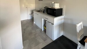 A compact kitchen with white cabinets, a microwave, and a coffee maker. - River Gardens Axedale Pet friendly B & B Farm stay - Motel Room (Axedale)
