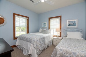 A bedroom with two beds, a desk, and a ceiling fan. - Sound Choice:Oceanfront Home;Sunset Views/Dolphin Sightings on St. Helena Sound; Screened Porch (Edisto Beach)
