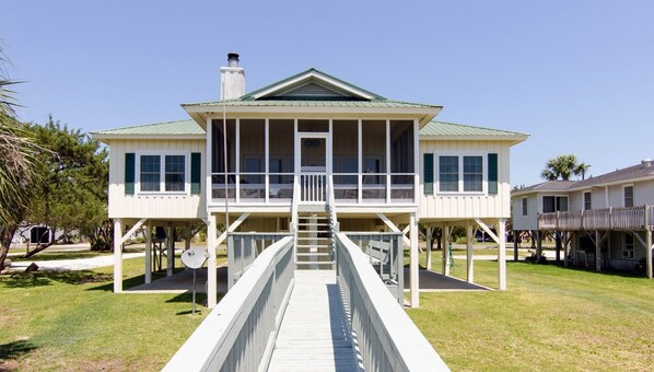 A two-story house with a balcony and a covered walkway leading to the entrance. - Sound Choice:Oceanfront Home;Sunset Views/Dolphin Sightings on St. Helena Sound; Screened Porch (Edisto Beach)