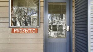 A house with a gray door, a window with blinds, and a sign reading "PROSECCO". - Prosecco - Dinner Plain (Dinner Plain)
