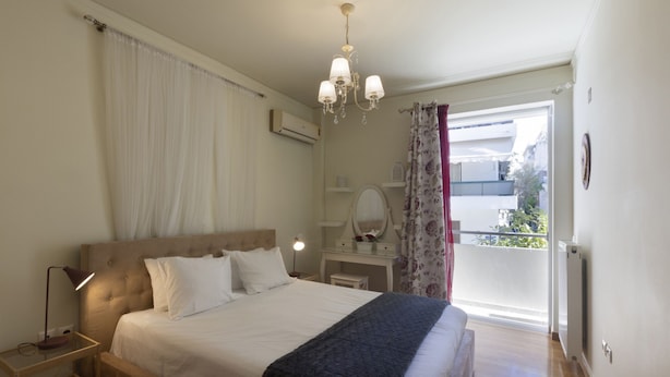 A bedroom with a large bed, bedside tables, a dresser, a chandelier, and a view of the outside. - MisaraliotouA3 · 3BR Prime APT a breath away from (Athens)