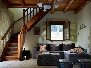 Relax in this inviting living room with a sofa set and a large window offering a view of the outdoors.