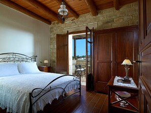 Cozy retreat with a wooden bed, nightstand, and stone wall.