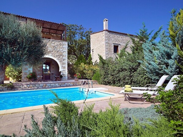 Relax by the serene pool surrounded by lush greenery.