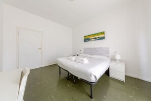 Une chambre à coucher avec un lit, une table de chevet et un tableau accroché au mur.