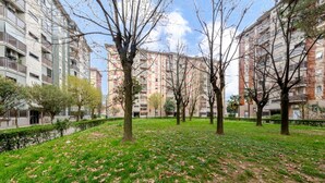 A park with trees and grass, surrounded by apartment buildings. - GuestHost - Bonola M1 Underground Bright & Functional Apt x4 (Milano)