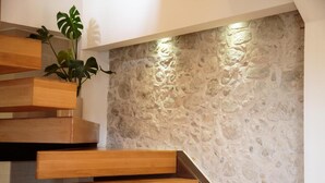 A staircase with wooden steps and a textured stone wall. - Unique vacation in traditional Cretan village in the mountains with family (Zaros)