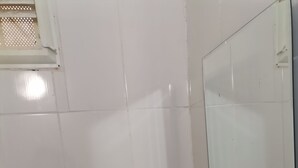 A bathroom with white tiles, a toilet, a bidet, a sink, and a mirror. - Marina Pansiyon (Silivri)