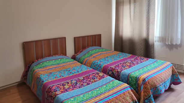 A room with two beds, each with a colorful striped bedspread. - Marina Pansiyon (Silivri)