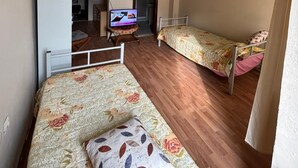 A dormitory room with two single beds, a television on a small table, and a wardrobe. - Marina Pansiyon (Silivri)