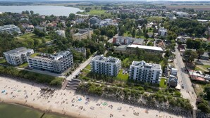 An aerial view of a coastal town with modern buildings, a beach, and a river. - Air-conditioned Studio 50 m from the Beach | Parking | Gym (Mielno)