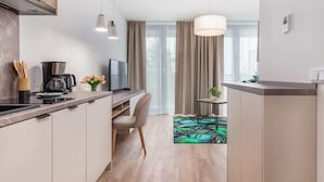 A modern kitchen with a dining area, a TV, and a coffee maker. - Air-conditioned Studio 50 m from the Beach | Parking | Gym (Mielno)