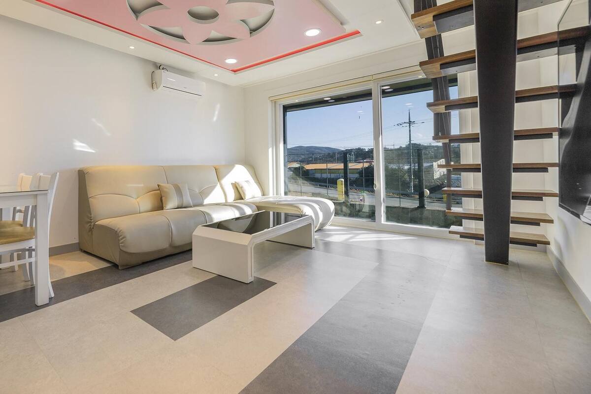 Una sala de estar moderna con un sofá, una mesa de centro y un comedor con sillas.
